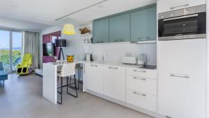 a kitchen with white cabinets and a dining room at The Hype Beachhouse in Playa de Palma