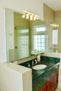 baño con lavabo y espejo grande en Casa Toscana Bed & Breakfast en San Miguel de Allende