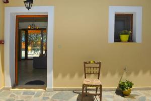 a wooden chair sitting in front of a house at Villa Platanaki in Kerveli