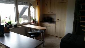 a kitchen with a counter and a table and a window at Studio Orchidee in Weißig