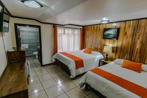 a hotel room with two beds and a bathroom at Mar Inn Costa Rica in Monteverde Costa Rica