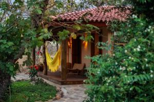 een klein huis met een gele gordijn op de veranda bij Pousada Trijunção in Rodeador