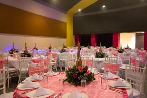 un salón de banquetes con mesas y sillas blancas en Hotel Ross, en Morelia