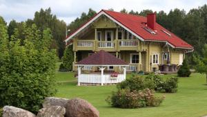 a large wooden house with a red roof at Veerpalu Villa in Otepää