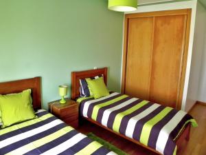 ナザレにあるApartamento Tonyの緑の壁の小さな部屋のベッド2台