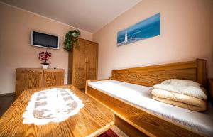 a bedroom with a large wooden bed and a tv at Wyspa Uznam - Apartament Moniuszki 5 in Świnoujście