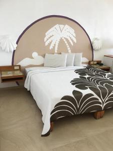 a bedroom with a large bed with a black and white bedspread at Palma Real in Manzanillo