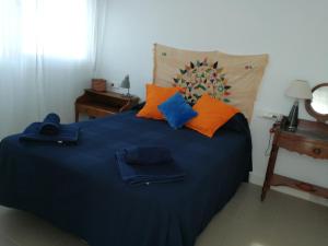 ラス・ネグラスにあるCasa Euphorbiaのベッドルーム1室(青いベッド1台、オレンジ&青い枕付)