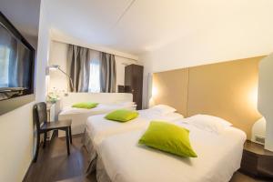 a hotel room with two beds and two lamps at Mandarina Hotel Luxembourg Airport in Luxembourg