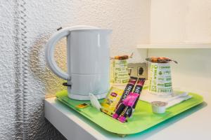 a coffee maker sitting on top of a shelf at Mandarina Hotel Luxembourg Airport in Luxembourg