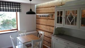 a kitchen with a wooden wall and a table and chairs at Dom Grabowa in Gilowice