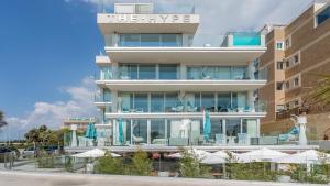 a building with a pool and chairs and umbrellas at The Hype Beachhouse in Playa de Palma