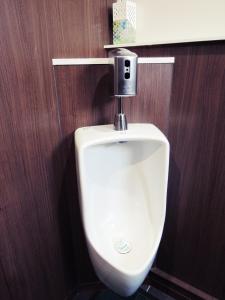 a urinal in a bathroom with a wooden wall at HOTEL LUCKY / Vacation STAY 3952 in Osaka