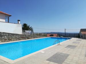 a swimming pool in a villa with blue water at Casa Esperança in Castro Daire