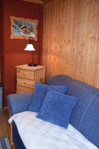 sypialnia z łóżkiem z niebieskimi poduszkami i lampą w obiekcie Ferienwohnung Suntinger w mieście Mörtschach