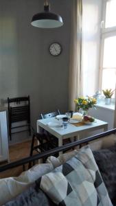 a living room with a table and a clock on the wall at Apartment Úvoz Street 64 in Brno