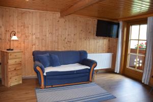 salon z niebieską kanapą i telewizorem w obiekcie Ferienwohnung Suntinger w mieście Mörtschach