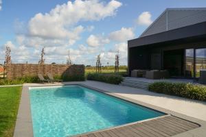 a swimming pool in front of a house at B&B Ten Doele in Middelkerke