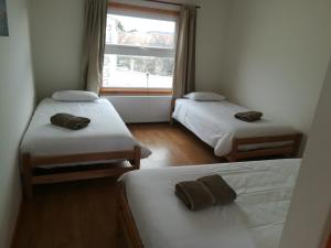a room with two beds and a window at Hostal Camino de Santiago in Puerto Natales