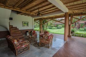 a porch with chairs and a table and a fireplace at Hotel Campestre el Fuerte in Rozo