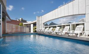 uma piscina com espreguiçadeiras num edifício em Scorial Rio Hotel no Rio de Janeiro