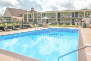 a large swimming pool in front of a hotel at Rose Garden Inn & Suites Thomasville in Thomasville