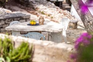a table and chairs with a bowl of flowers on it at Holiday house Karla in Vela Luka
