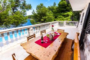 a wooden table on the deck of a house at Holiday house Karla in Vela Luka