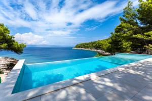 a swimming pool with a view of the ocean at Holiday house Karla in Vela Luka