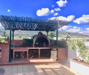 a patio with a pizza oven under a pergola at Villa Sara di Puglia in Castellaneta