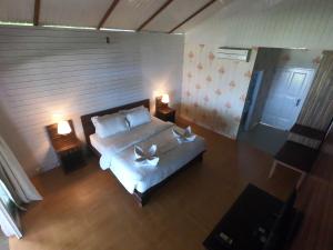 una camera da letto con un letto bianco e due lampade di BatuRundung Surf Resort a Naibos
