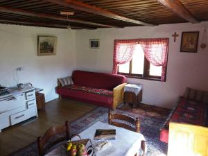 a living room with a red couch and a table at Etno guest house Lalovic in Tjentište