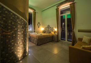 ラ・スペツィアにあるTeresa Rooms & Suitesのベッドルーム1室(ベッド1台、ソファ付)