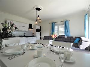 a dining room and kitchen with a white table and chairs at VIP Apartamenty KRUPÓWKI in Zakopane