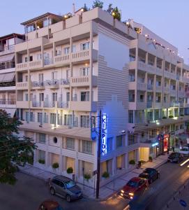 un grand bâtiment avec des voitures garées devant lui dans l'établissement Hotel Kierion, à Karditsa