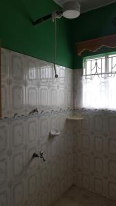 a bathroom with a shower and a green ceiling at Achill Houses in Thika +81 photos