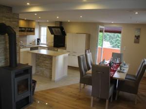 a kitchen and living room with a fireplace and a table and a stove at Bella la vita in Schopfloch