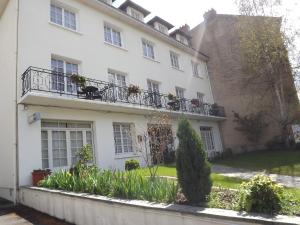 une maison blanche avec un balcon et des plantes dans l'établissement Hotel de L'Europe, La Roche-Posay, à La Roche-Posay