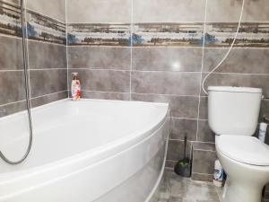 a bathroom with a white tub and a toilet at Apartment - Matusevycha Street 2-11 in Kryvyi Rih +6 photos