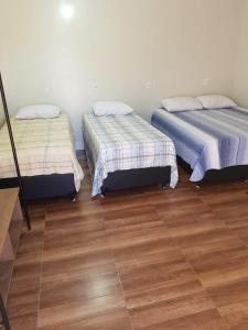 ラゴア・サンタにあるHotel Fazenda Flamarionのベッド2台が備わるウッドフロアの客室です。