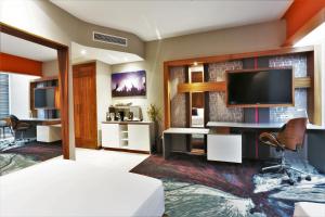 a living room with a tv and a desk with a chair at Hard Rock Hotel Guadalajara in Guadalajara