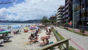 a group of people sitting on the beach at Apto na quadra do mar em Meia Praia Itapema, 2 dorm, 6 pessoas in Itapema