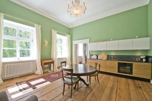 a kitchen with a table and chairs in a room at Schloss Retzow Apartments in Retzow