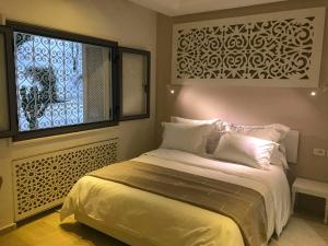 a bedroom with a bed and a window with a window treatment at Dar Corniche La Marsa (Adults Only) in La Marsa