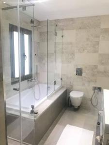 a bathroom with a shower and a tub and a toilet at Dar Corniche La Marsa (Adults Only) in La Marsa