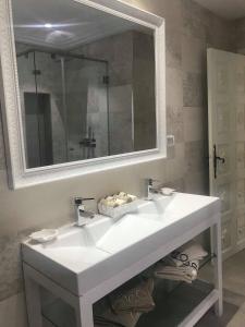 a bathroom with a white sink and a mirror at Dar Corniche La Marsa (Adults Only) in La Marsa