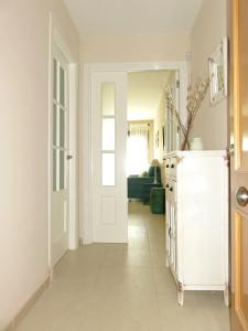 a white hallway with a door leading to a living room at Apartamento barrio San Miguel in Jerez de la Frontera