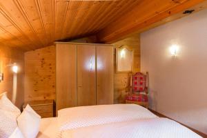 ein Schlafzimmer mit einem Bett und einer Holzdecke in der Unterkunft apart strolz in Sankt Anton am Arlberg