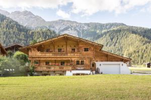 a large wooden house with a balcony and a garage at apart strolz in Sankt Anton am Arlberg