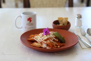 a plate of pasta with a purple flower on a table at Casa de la Gente Nube in Puerto Escondido